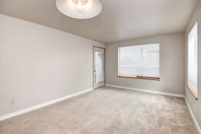 Seattle Apartments-  Living area with a large window and beige carpet