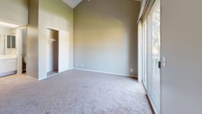 Apartments for Rent Ontario CA - Rancho Vista - Unfurnished Bedroom With Open Bathroom Counter and Sink, Carpet Floors, a Closet, and a Sliding Glass Door