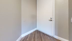 Apartment Ontario CA - Rancho Vista - Apartment Door With White Paint, a Deadbolt, and Wood Styled Flooring