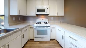 Apartments for Rent in Ontario CA  - Rancho Vista - Modern Kitchen With a Gas Stove, a Microwave, Sleek Counters, and Spacious Cabinets