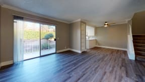 Dog Friendly Apartments in Ontario CA - Rancho Vista - Unfurnished Living Room With Wood Floors, Natural Lighting, and a Sliding Glass Door Leading to the Patio