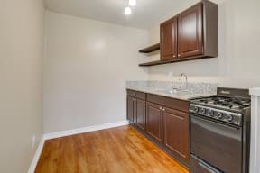 Apartments for Rent in Colton, CA - Las Brisas Kitchen with Stainless Appliances, White Cabinets, Plank Flooring, and Granite Countertops