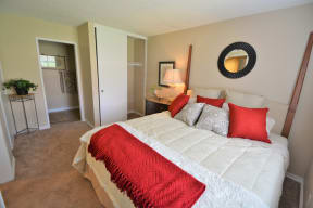 The Arches at Regional Center West Apartments in Antelope Valley - Bedroom with Stylish Decor, Wall to Wall Carpet, White Walls, Sliding Door Closet, and Access to Bathroom