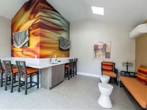 Ontario Apartments - Encore - Community Clubhouse with TV, Sink, and Orange Furniture