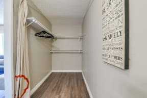Colton, CA Apartments - Las Brisas Walk-In Closet with Shelves and Hangers, Beige Walls, and Plank Flooring