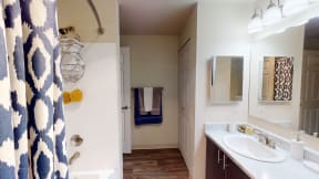 Ontario Apartments for Rent - Encore Apartment Homes - Bathroom with a Dark Wood-Style Cabinets, Large Mirror, Towel Rack, and Medicine Cabinet