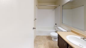 Apartments For Rent in Ontario - Encore Apartment Homes - Bathroom with Tub and Shower Combo, Single Vanity, and Large Mirror
