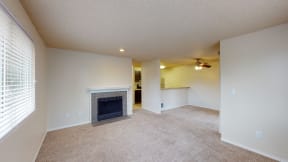 Dog-Friendly Apartments in Ontario CA - Encore Apartment Homes - Open-Concept Living Room with Plush Carpeting, Large Window, and a Fireplace