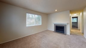 Apartments in Ontario CA - Encore Apartment Homes - Living Room with Plush Carpeting, a Fireplace, and a Window