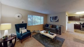 Apartments in Ontario - Encore Apartment Homes - Living Room with Plush Wall to Wall Carpet, Stylish Decor, Large Windows, and Access to Kitchen