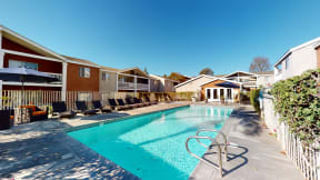 Apartment Ontario CA - Rancho Vista - Outdoor Pool With Clear Water, Lounge Chairs, Additional Seating With Umbrellas, and a Fenced Perimeter