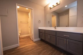 Apartments Near Ontario Mills - Aspire Upland - Bathroom With Separate Toilet and Shower, Spacious Cabinets, and a Large Mirror
