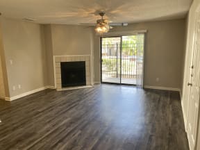 spacious living room with wood plank floors and fire place at Avisa Lakes Apartments