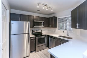 Renovated kitchen with dark cabinets, light counters