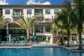 Pool deck with lounge chairs and umbrellas  | District at Rosemary