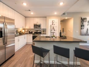 kitchen with island, white cabinets and stainless steel appliances