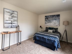 a bedroom with a bed and two paintings on the wall