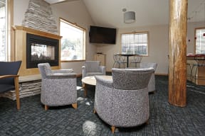 Community room lounge area with stone fireplace and breakfast bar by the windows.