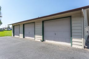 White detached garages on a long driveway available to residents.