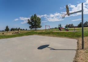 Outdoor basketball court looking out onto playground.