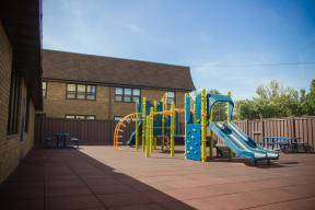 Outdoor community playground with a bright playset in a spacious area.