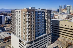Exterior view of Civic Lofts building and parking structure, with view of Denver skyline