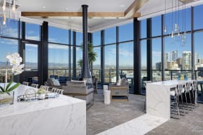 Sky lounge with fireplace connected to the ceiling, surrounding seating and large windows with view of Denver skyline