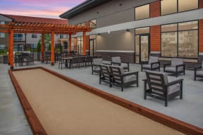 Outdoor patio with bocce ball court off the clubhouse with the pergolas in the background.