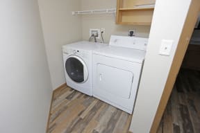 In unit washer and dryer side by side with shelf storage above.