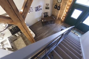 Bird's eye view of entry way from top of staircase showcasing multi-level unit.