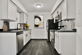 Kitchen with Appliances, White Cabinets and Dark Hard Wood Flooring