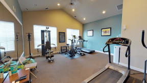 Secondary view of fitness center featuring two large windows and a mirrored wall with extra room to exercise.