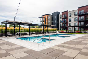 Outdoor pool at Ironwood complete with gazebos, lounge seating, and lights hanging above the deck.