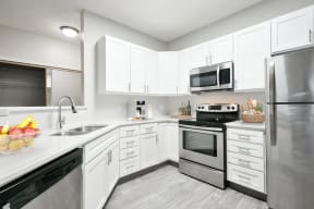 Modern and spacious kitchen with white cabinetry, stainless steel appliances, and plenty of storage.