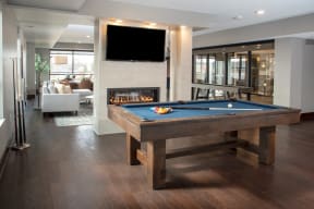 Community room with pool table, fireplace and mounted flatscreen