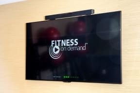 Television in fitness center with fitness on demand logo on screen