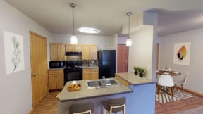 Open kitchen with island, wood cabinetry, and pendant lighting. Separate dining area is to the right of the kitchen in this image.