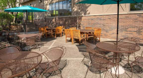 Outdoor community patio with umbrella tables and outdoor dining tables.