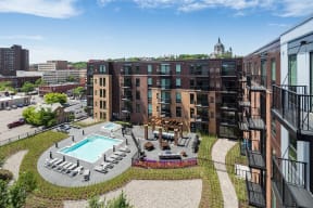 Stunning panoramic view from the balcony at Oxbo Urban Rentals. Large pool deck, outdoor lounge area, and St Paul skyline can be seen from the balcony.