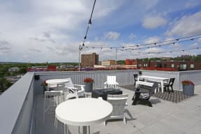 Stunning rooftop with string lights, casual dining area, and lounge seating.