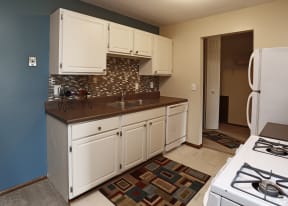 Side view of a modern kitchen with tile backsplash and wine bottle holder on the counter.