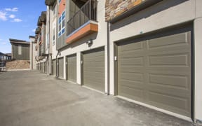 Outdoor private car garages with apartment balconies overhead