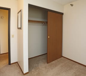 Closet with sliding wood door in carpeted bedroom