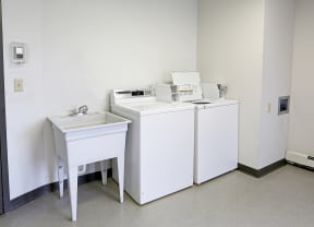 Laundry room with washer and dryer next to small washing sink