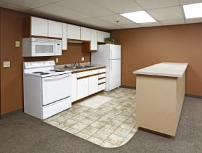 Kitchen with tile floor breakfast bar, white cabinets and appliances