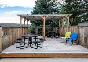 Outdoor community picnic area complete with seating, tables, and a pergola for shade.