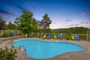 Outdoor pool at night with views of the Black Hills in the background.