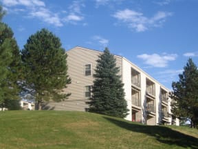 Pointe West building exterior showcasing unit balconies with the building lined by trees.