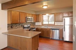Full Kitchen with Attached Island, Wood Cabinets and Stainless Steel Appliances