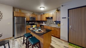 Updated kitchen with stainless steel appliances, wood cabinetry, and an island for casual dining.